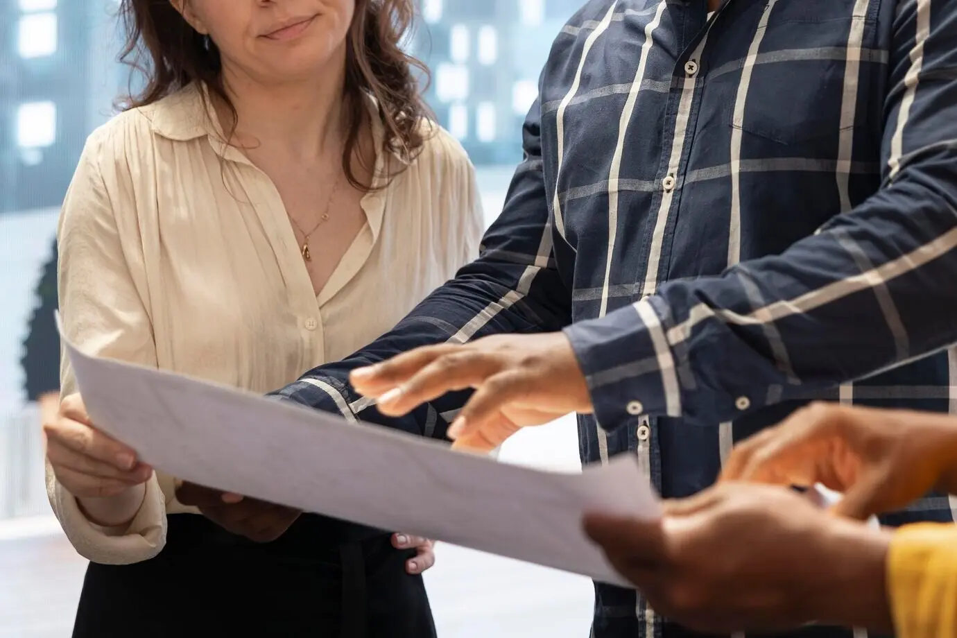 Fachkundiger Immobilienmakler präsentiert den Kunden die Baupläne mit rechtlicher Unterstützung.